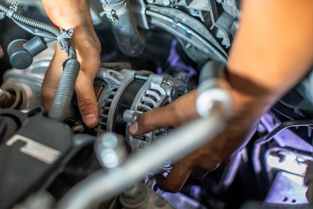 A technician holding an alternator